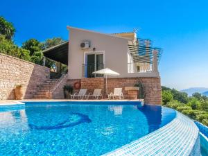 a villa with a swimming pool in front of a house at Villa Vigla in Kalami