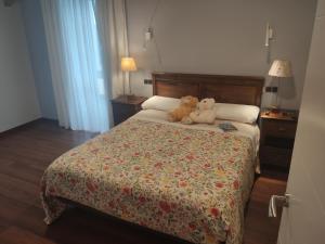 two teddy bears sitting on a bed in a bedroom at Apartamentos San Román in Retorta +20 photos