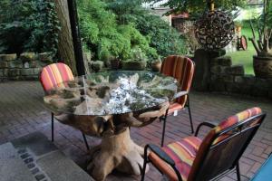 a stone table with four chairs and a fountain at Ferienpark Leitzingen in Soltau