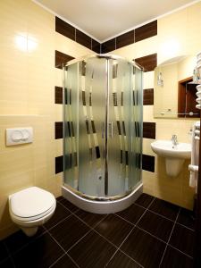 a bathroom with a shower and a toilet and a sink at HOTEL NIAGARA in Konin