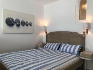 a bedroom with a bed with blue and white stripes at VILLA IL BLU direkt am Meer in Martinšćica