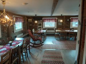 a dining room with wooden tables and chairs and a chandelier at Reindeer Lake Resort in Lampsijärvi
