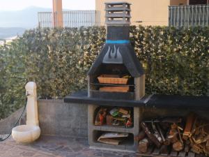 un horno de pizza al aire libre sentado en la parte superior de una pared en Appartamento Belvedere Sassos, en Tresnuraghes