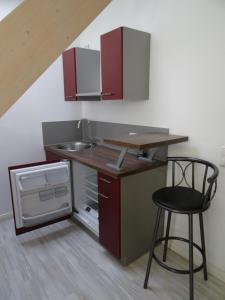 a small kitchen with a counter and a stool at Airport Park Hotel MUC in Hallbergmoos