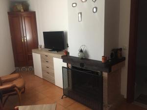 sala de estar con chimenea y TV en Apartamento Sierra León, en El Bosque