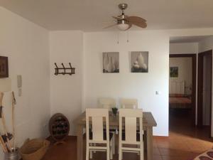a dining room with a table and white chairs at Apartamento Sierra León in El Bosque