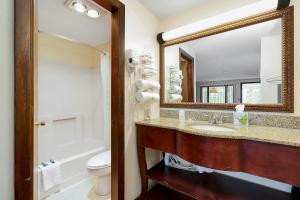W łazience znajduje się umywalka, lustro i toaleta. w obiekcie USA Inn w mieście Wells