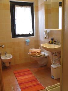 a bathroom with a sink and a toilet and a window at Art Apartments Casa Napell in Livigno