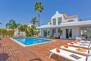 eine Villa mit einem Pool und Liegestühlen in der Unterkunft Villa Maresia Dourada in Guia