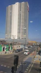 a street with cars parked in front of tall buildings at Edificio Bulnes - Cavancha in Iquique