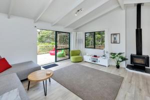 een woonkamer met een bank en een open haard bij Lofty Te Haumi - Paihia Holiday Home in Paihia