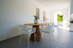 ein Esszimmer mit einem Holztisch und Stühlen in der Unterkunft Le Agavi - Villa esclusiva per vacanze in Carini