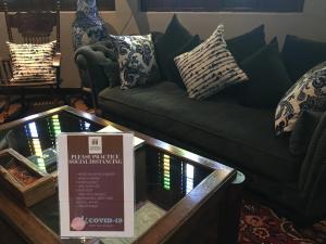 a living room with a green couch and a sign at Campbell House in George Town