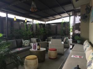 a patio with couches and tables and plants at Campbell House in George Town