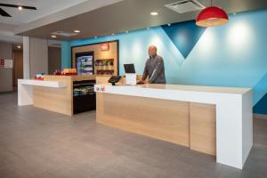 a man standing at a counter in a store at avid hotels - Madison - Monona by IHG in Monona