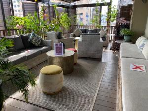 a outdoor patio with couches and tables and plants at Campbell House in George Town