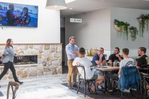 a group of people sitting at a table in a restaurant at The Ophir Hotel in Orange