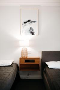 1 dormitorio con 2 camas y mesita de noche con una foto en The Ophir Hotel en Orange