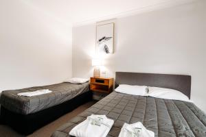 Un pat sau paturi într-o cameră la The Ophir Hotel