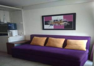 a purple couch with two pillows in a living room at The Edge By Orin in Cimindi-hilir