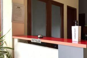 un mostrador rojo en una habitación con espejo en Kemang Place near Lippo Mall Kemang Mitra RedDoorz, en Yakarta