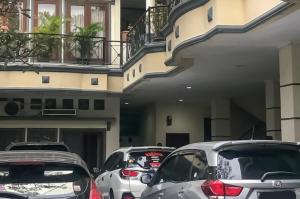 una fila de autos estacionados frente a un edificio en Kemang Place near Lippo Mall Kemang Mitra RedDoorz, en Yakarta