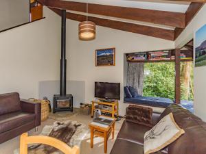 uma sala de estar com um sofá e uma lareira em Foyle Street Chalet - Ohakune Holiday Home em Ohakune