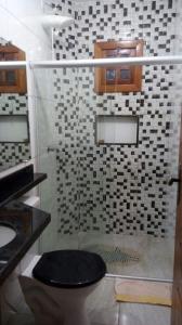 uma casa de banho com um chuveiro e um WC. em Recanto Calua em Serra Grande