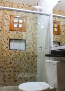 y baño con aseo y ducha acristalada. en Recanto Calua, en Serra Grande