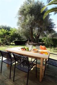 Villa Rosa Apartments في جوفيا: طاولة مع كراسي وفواكه على الفناء