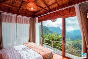 a bedroom with a bed and a large window at Heaven Gate Hotel O Quy Ho in Lao Cai