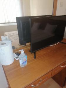einen Flachbild-TV auf einem hölzernen Schreibtisch in der Unterkunft Guest House Nani in Assenowgrad
