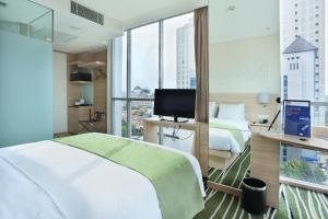 Cette chambre comprend deux lits et une télévision. dans l'établissement Holiday Inn Express Semarang Simpang Lima, an IHG Hotel, à Semarang