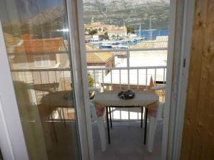 een balkon met een tafel en uitzicht op een haven bij Apartments Neno in Korčula