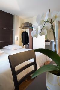 A bed or beds in a room at Escale Oceania Rennes Cap Malo