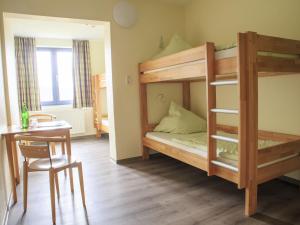 a room with two bunk beds and a table at SGV Jugendhof in Arnsberg