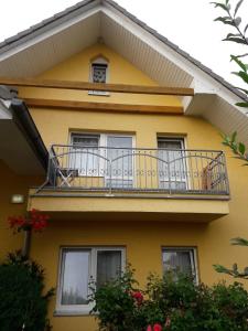 a yellow house with a balcony with a dog on it at SŁONECZNIK in Rewal