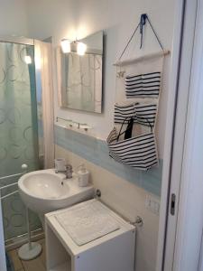 ein weißes Badezimmer mit einem Waschbecken und einem Spiegel in der Unterkunft Vacanze da Favola in Castelsardo