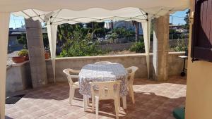 - une table et des chaises sous un parasol sur la terrasse dans l'établissement Casa vacanza fronte mare, à Capilungo