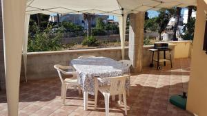 - une table et des chaises sous un parasol sur la terrasse dans l'établissement Casa vacanza fronte mare, à Capilungo