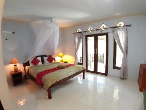 a bedroom with a bed and a large window at Mangga homestay Gili air in Gili Air
