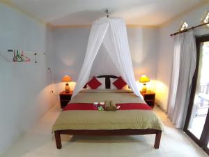 een slaapkamer met een hemelbed bij Mangga homestay Gili air in Gili Air