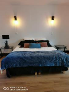 a bedroom with a large bed with a blue blanket at La Tour notre Dame in Boulogne-sur-Mer