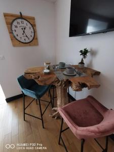 a wooden table with chairs and a clock on the wall at La Tour notre Dame in Boulogne-sur-Mer +7 photos