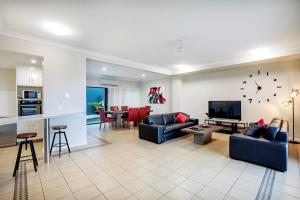 a living room filled with furniture and a tv at Toscana Village Resort in Airlie Beach