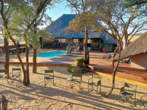 a resort with a pool and chairs and a building at Woodside Game Lodge in Morokwa