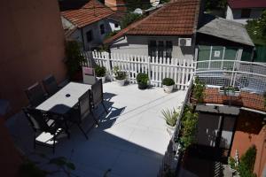 patio ze stołem, krzesłami i białym płotem w obiekcie Apartment Sleep'n Drive w Belgradzie
