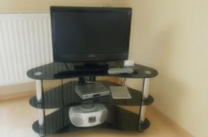 a computer monitor on a stand with a computer system at Ferienwohnung Am Kanadablick in Stützengrün