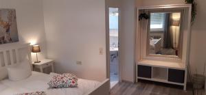 um quarto branco com uma cama e um espelho grande em Hotel Bären Garni em Friburgo em Brisgóvia