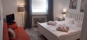 ein Schlafzimmer mit einem weißen Bett mit Kissen darauf in der Unterkunft Hotel Bären Garni in Freiburg im Breisgau
